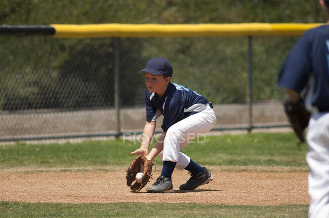Infielder baseball Little League in campo una palla di terra — Foto stock