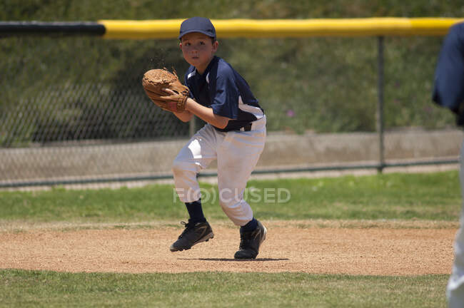 Pequeña Liga de béisbol infielder fielding una bola de tierra - foto de stock