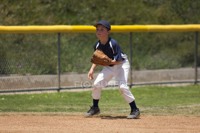 Pequeña Liga de béisbol infielder listo para una pelota de tierra - foto de stock