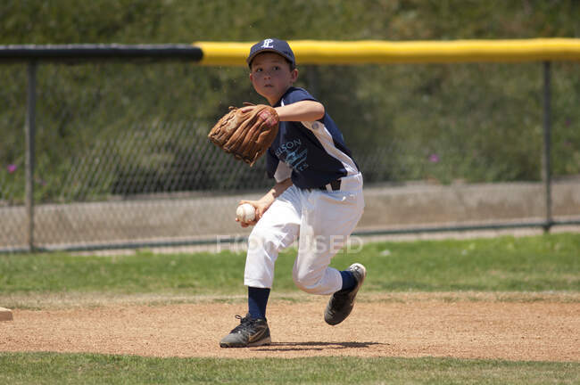 Little League infielder about to throw the ball to first base — Stock Photo