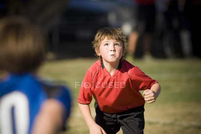 Рішучий молодий хлопчик готовий очолити футбольний м'яч — стокове фото