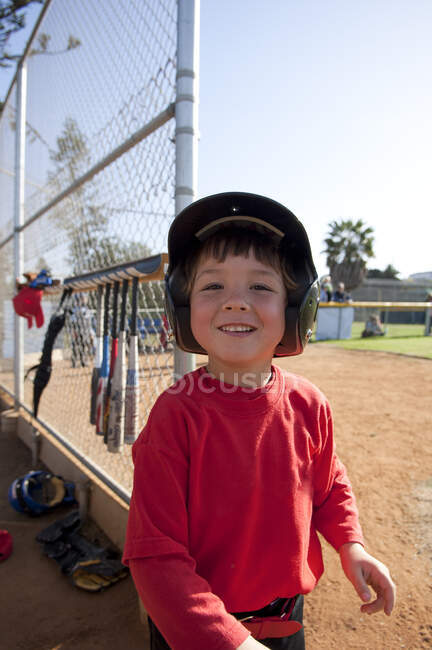 Young boy smiling near the TBall dugout — Stock Photo