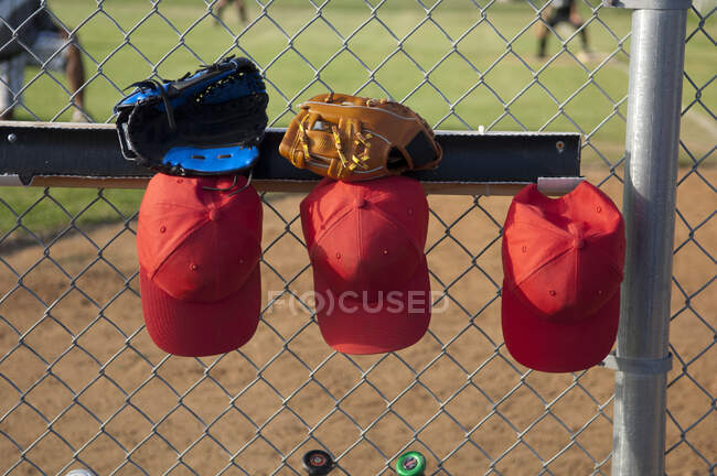 Hats and gloves hanging in a TBall dugout — Stock Photo