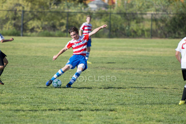 Adolescente jogador de futebol prestes a bater a bola em um chute livre — Fotografia de Stock