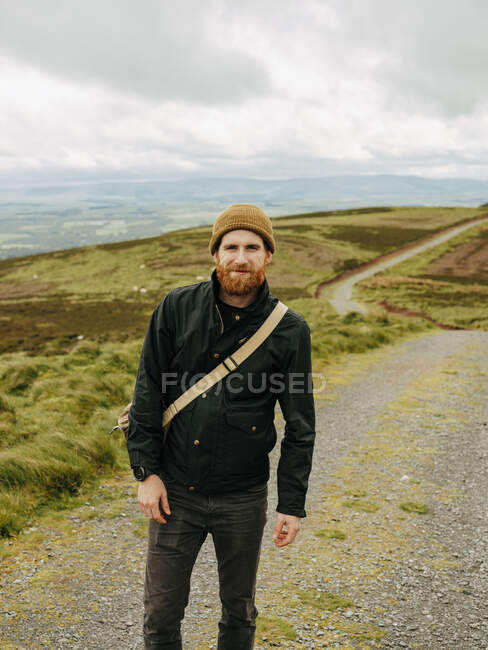 Усміхнений бородатий чоловік на сільській гравійній дорозі — стокове фото