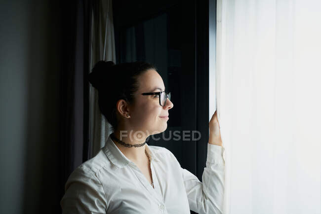 Young woman looking at the window — Stock Photo