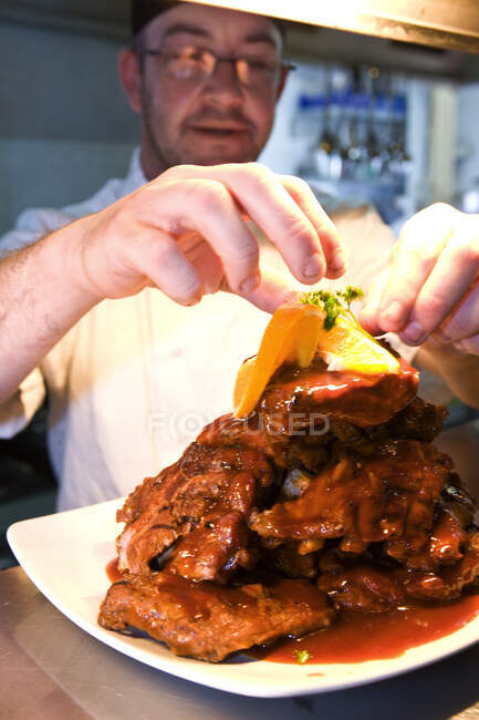 Chef mettendo tocco finale al suo piatto prima di servirlo — Foto stock