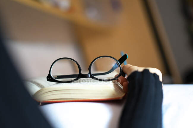 Lectura de gafas en la parte superior de un libro. Concepto de gafas graduadas . - foto de stock