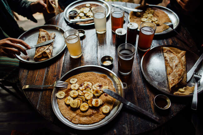 Сніданок з чашкою кави і келихом вина на дерев'яному столі. — стокове фото