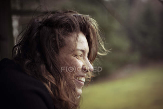 Beautiful wild free natural young woman looks out over field in wind — Stock Photo