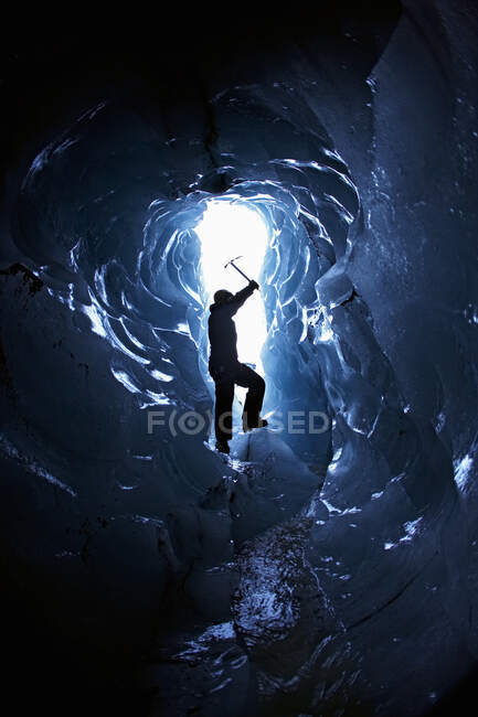 Silhouette d'homme mûr à l'entrée d'une petite grotte de glace — Photo de stock