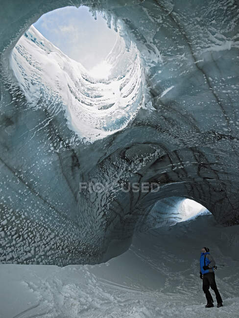 Hombre explorando cueva de hielo en Islandia - foto de stock