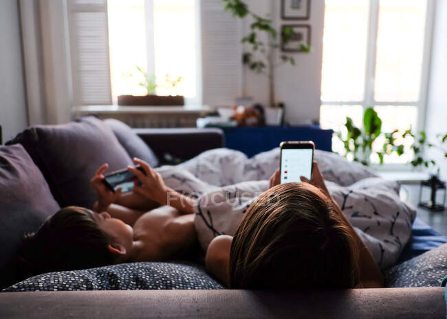 Mother and son are watching smartphones — Stock Photo