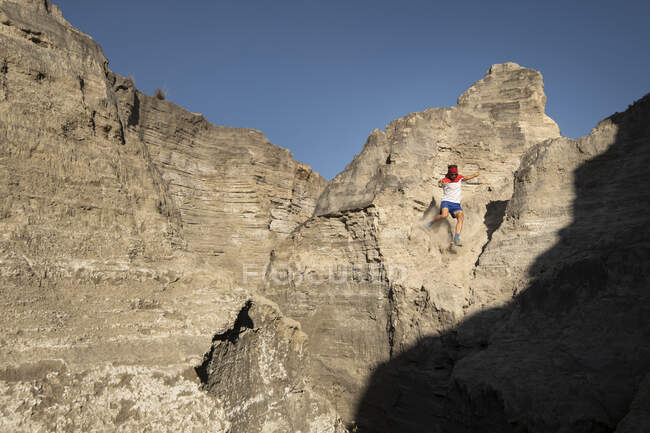 A man trail running down on technical terrain leaving dust on his way — Stock Photo