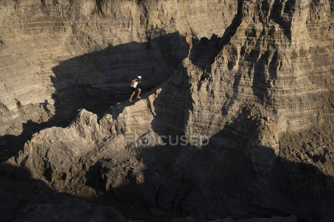 Uma trilha de homem correndo em terreno técnico deixando poeira em seu caminho — Fotografia de Stock
