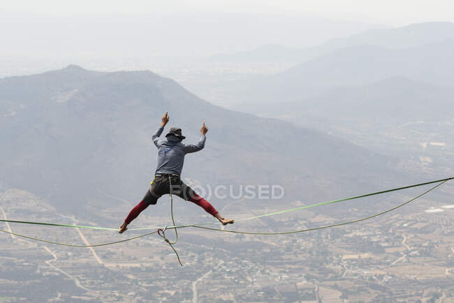 Un homme équilibre avec les jambes ouvertes dans une ligne haute à Los Frailes — Photo de stock