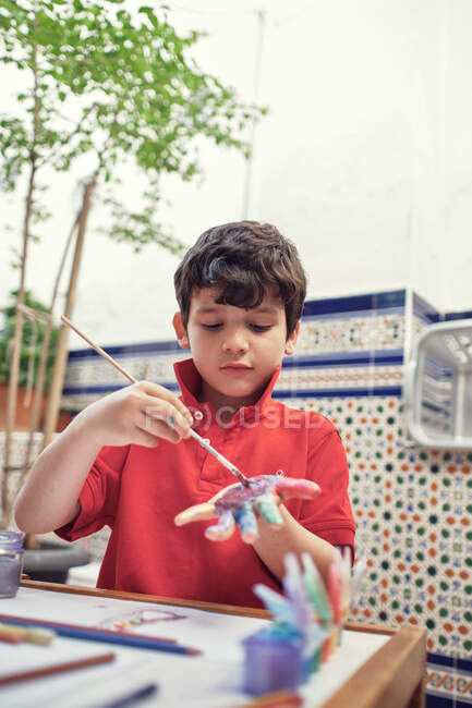 Niños jugando en un patio interior y pintando con pinturas al agua - foto de stock