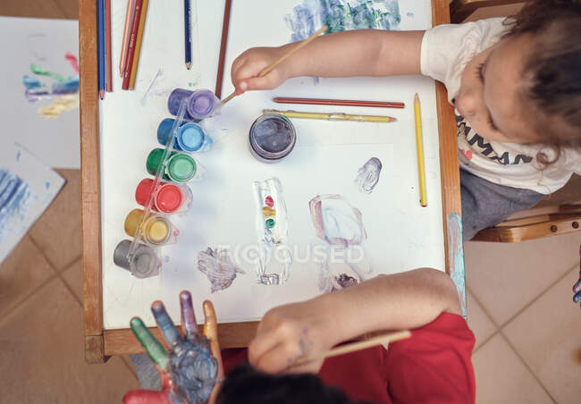 Kinder spielen im Innenhof und malen mit Wasserfarben — Stockfoto