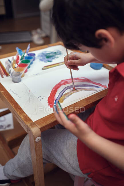 Niños jugando en un patio interior y pintando con pinturas al agua - foto de stock