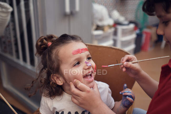 Children playing in an inner courtyard and painting with water paints — Stock Photo