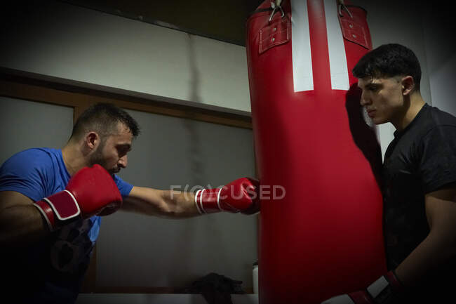 Uomo caucasico che pratica la boxe con la borsa — Foto stock