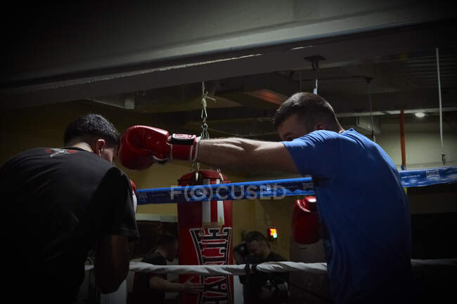 Dos boxeadores entrenando en un anillo de gimnasio - foto de stock