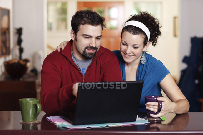 Trabajo en pareja en el ordenador portátil en casa - foto de stock