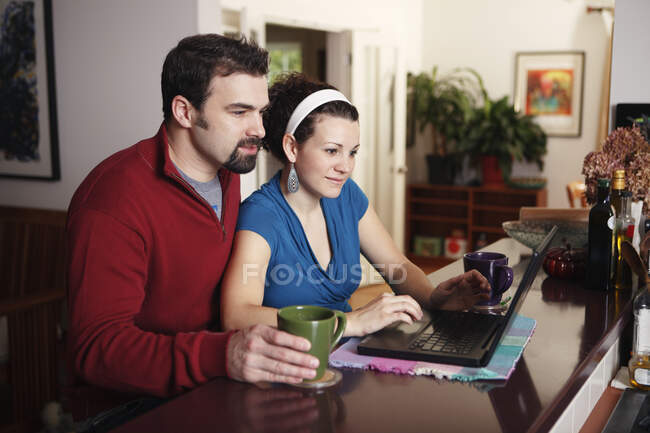 Trabajo en pareja en el ordenador portátil en casa - foto de stock