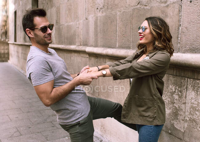 Young and attractive couple holding hands play, and show their a — Stock Photo