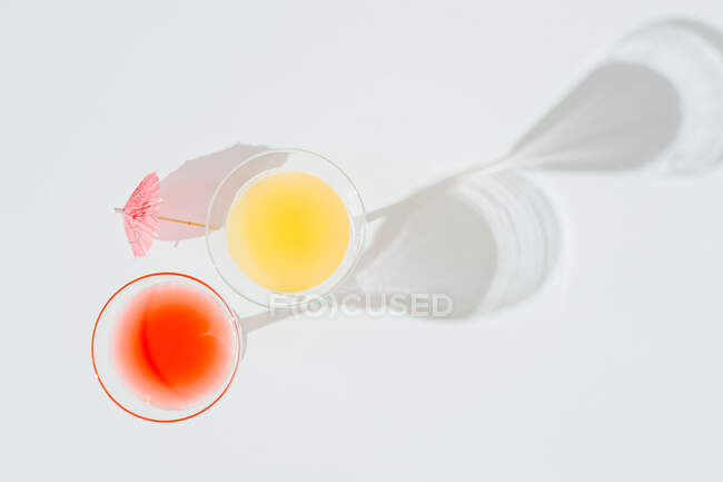 Alcoholic cocktails with marked shadows of the midday sun. Refreshing drinks for summer — Stock Photo