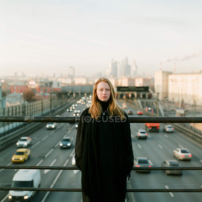 Женщина стоит на закате у моста — стоковое фото