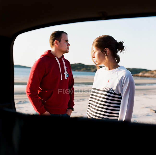 Uomo e donna in piedi sulla riva del mare — Foto stock