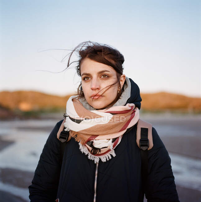 Una donna si trova sulla riva del mare vicino alla montagna — Foto stock