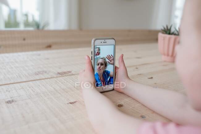 Nurse blowing a kiss on a video call with home at the hospital — Stock Photo
