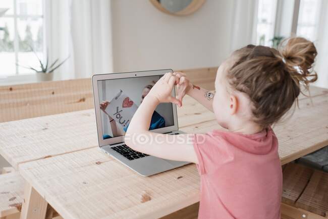 Young girl chatting with a nurse on video call saying I love you — Stock Photo