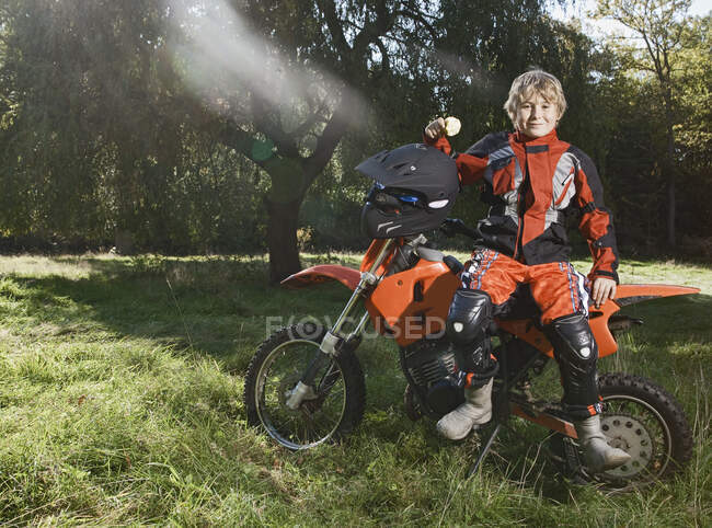 12 ans garçon avoir une pause sur sa moto hors route — Photo de stock