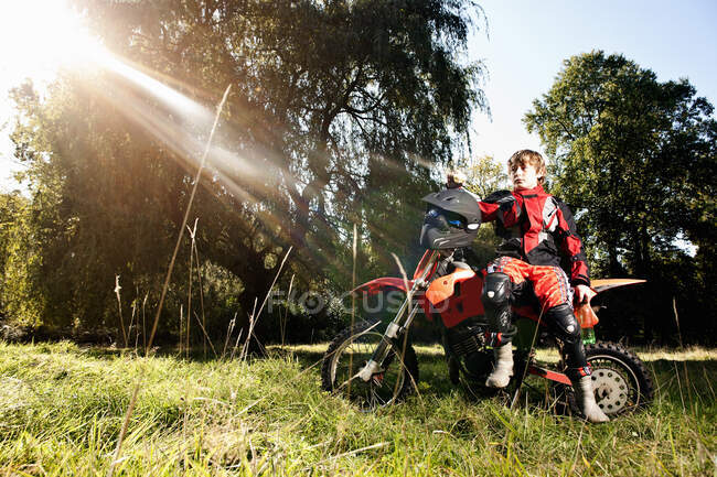 12 anno vecchio ragazzo avendo un pausa su suo off strada moto — Foto stock