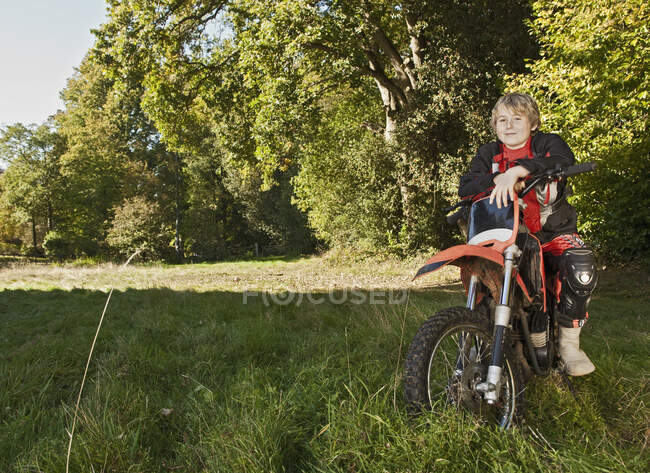 12 anno vecchio ragazzo avendo un pausa su suo off strada moto — Foto stock