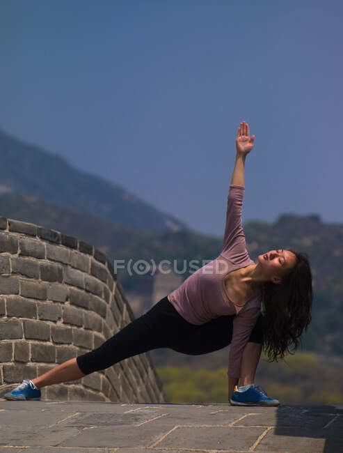 Жінка практикує йогу на Великому китайському мурі. — стокове фото