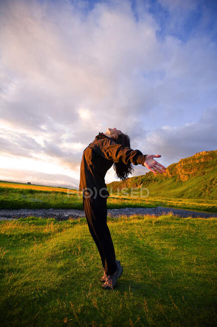 Mulher chinesa se alongando ao pôr do sol na Islândia — Fotografia de Stock
