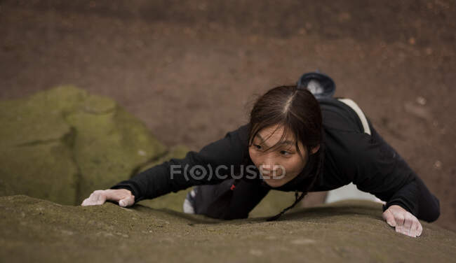 Femme bloquant sur la pierre de la grille dans le Peak District / Royaume-Uni — Photo de stock
