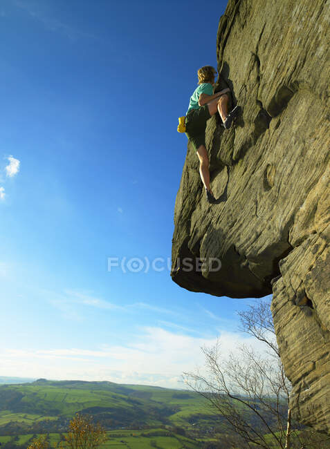 Hombre de bouldering en grilla de piedra en el Peak District / Reino Unido - foto de stock