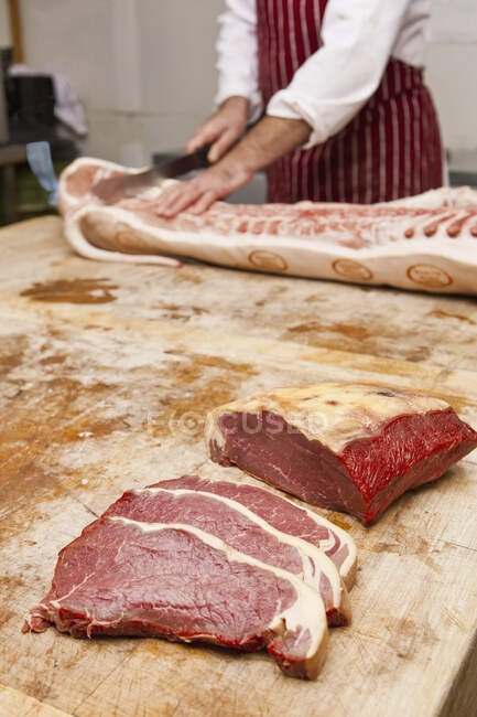 Açougueiro esculpindo carne na loja — Fotografia de Stock