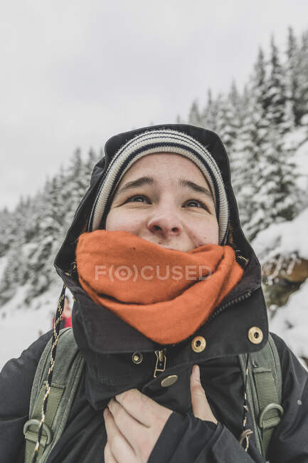 Porträt einer jungen Frau, die im Winter lächelnd und glücklich nach oben blickt — Stockfoto