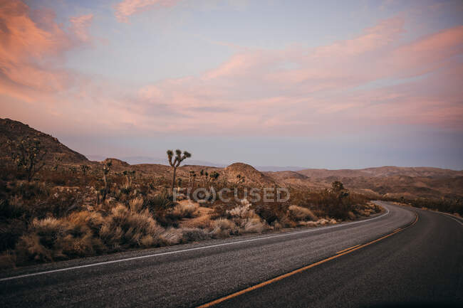 Windy road around Mojave desert of Joshua Tree National Park at sunset — Stock Photo
