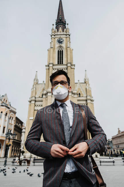 Geschäftsmann steht mit Mundschutz auf der Straße — Stockfoto