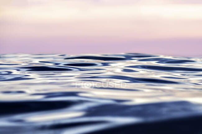 Sunset with smooth sea, close up waves — Stock Photo