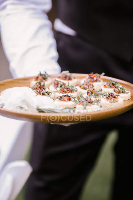 Passed Appetizers on wood tray in server's hand — Stock Photo