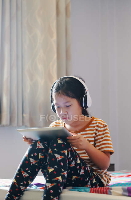 Girls use a tablet and listen to music with headphones — Stock Photo