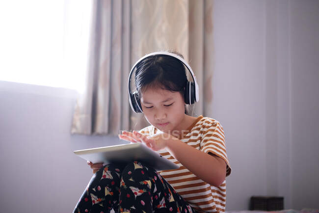 Les filles utilisent une tablette et écoutent de la musique avec des écouteurs — Photo de stock